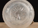 a clear glass bowl on a wooden table with a black background