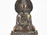 a bronze statue of a buddha sitting on a lotus flower