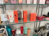 a glass shelf with many different types of beauty products on it