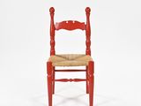 a red wooden chair with a woven seat on a white background