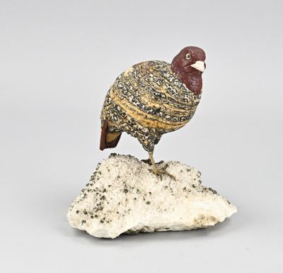 figurine représentant un oiseau perché sur un rocher, posée sur un fond blanc