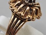 a close up of a gold ring with a diamond in the center