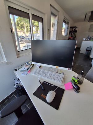 un bureau sur lequel se trouvent un ordinateur, un clavier et une souris