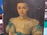 une photo d'un tableau représentant une femme, posé sur une table