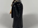 a black purse with a gold chain hanging from it