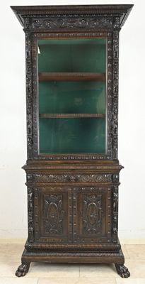 an old wooden cabinet with a green glass door and shelves