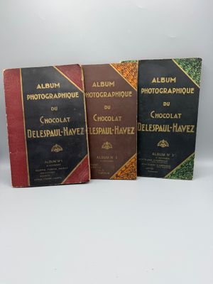 three books are lined up on top of each other on a white surface
