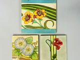 trois carreaux ornés de fleurs et de feuilles sur un fond blanc