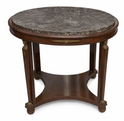 une table basse ronde au plateau en marbre et au piètement en bois