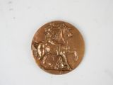 bronze medal depicting a horse and rider on a white background