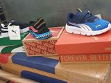 a pile of children ' s shoes sitting on top of boxes
