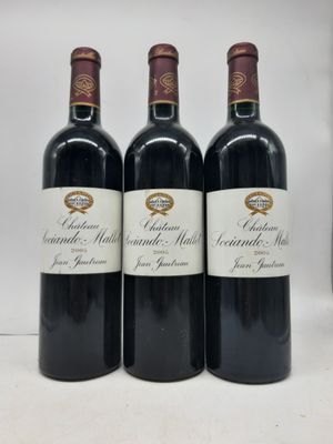 trois bouteilles de vin rouge posées sur un plan de travail blanc