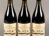 trois bouteilles de vin posées sur une table l'une à côté de l'autre
