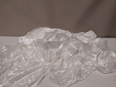 un objet blanc posé sur une table recouverte d'une nappe blanche
