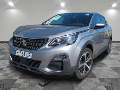 une voiture argentée est garée dans une pièce au sol en damier