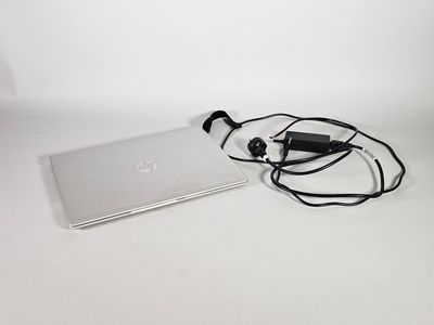 un ordinateur portable et un casque posés sur une surface blanche