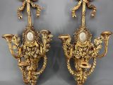 une paire d'appliques murales anciennes, chacune dotée d'une horloge