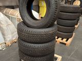 several tires stacked on pallets in a warehouse with pallets in the background