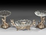 trois bougeoirs en métal plaqué argent, ornés de fleurs et de feuilles