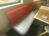 un banc rouge et blanc dans un coin de la pièce