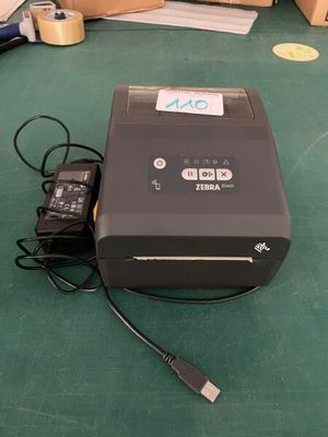 a printer that is sitting on the floor next to a charger
