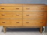 an image of a wooden chest of drawers on a grey background