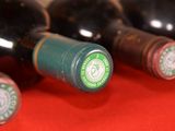 several bottles of wine are lined up on a red table