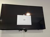a flat screen tv mounted on the wall with a sign on it