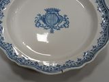 a blue and white plate with a crest on it