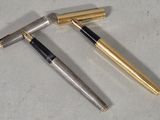 two pens sitting next to each other on top of a table