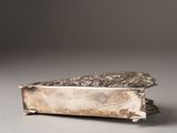 a silver box that has a silver decoration on it