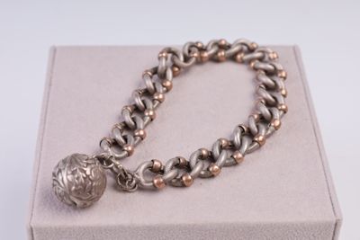 bracelet en argent et en or orné d'une breloque en forme de boule montée sur un fermoir à boîtier