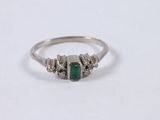 a close up of a silver ring with a green stone on it