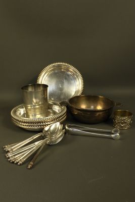 an assortment of silverware including a bowl, spoon, and spoon rest