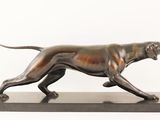 bronze statue of a dog on a marble base on a white background