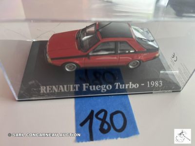 une petite voiture rouge dans une vitrine posée sur une table