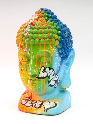 une statue colorée représentant une tête de Bouddha sur fond blanc