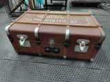a brown trunk sitting on top of a metal floor
