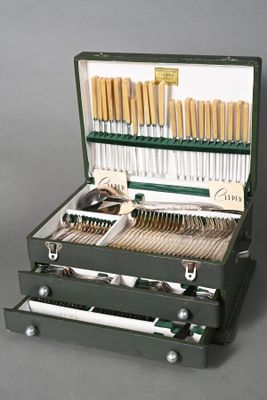 a green case with silverware in it on a gray surface