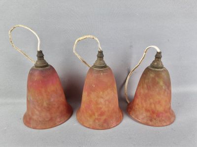 trois petites décorations en forme de cloche sont disposées les unes à côté des autres