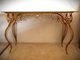 une table avec un plateau en verre et un piètement en métal