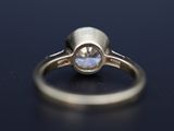 a close up of a gold ring with a white diamond