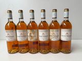 six bottles of wine are lined up in a row on a table