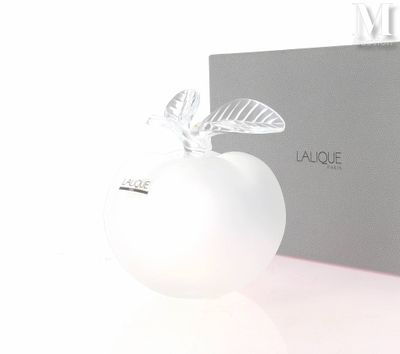 une pomme blanche avec une feuille dessus, à côté d'une boîte