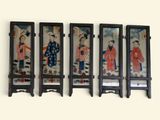 four framed asian paintings hang on a wall in a row