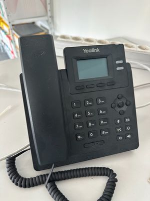 a telephone that is sitting on a desk next to a keyboard