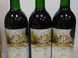 three bottles of wine sitting on top of a counter next to a bag
