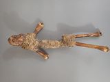 une sculpture en bois représentant une personne allongée par terre
