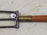 a wooden handled fork with a metal handle on the floor