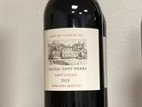 deux bouteilles de vin posées sur une étagère l'une à côté de l'autre
